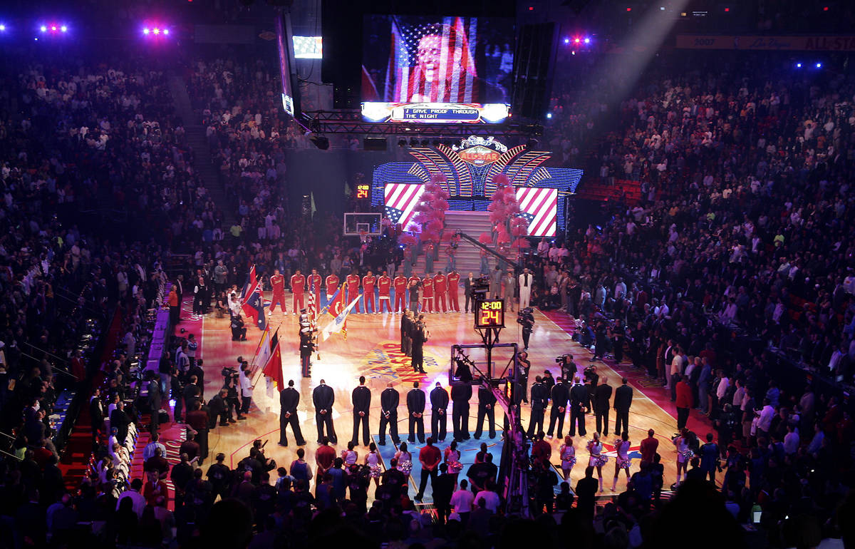 Basketball fans stand as Las Vegas headliner Danny Gans and his band sing the National Anthem b ...