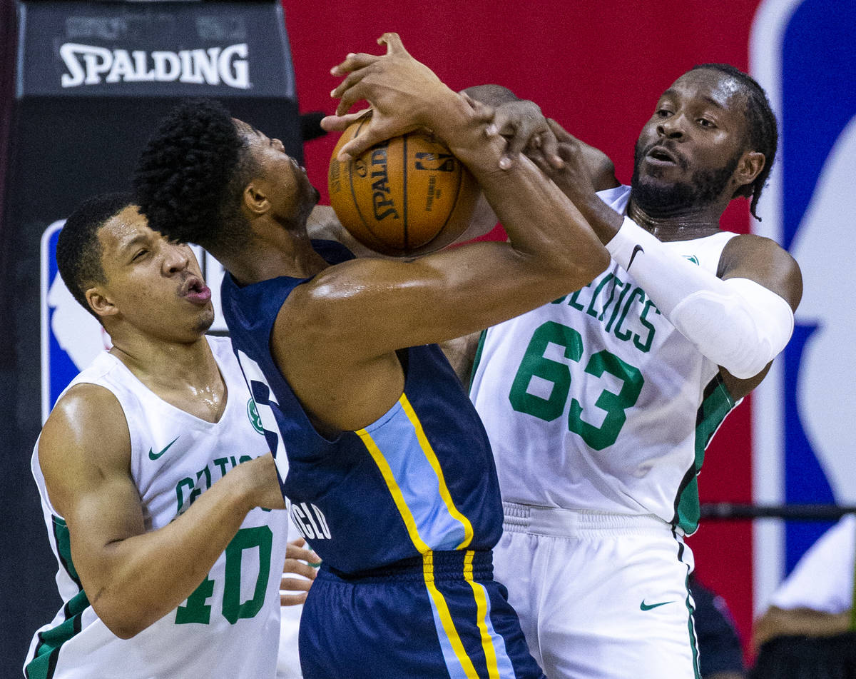 Memphis Grizzlies forward Bruno Caboclo, center, fights for a rebound with Boston Celtics cente ...