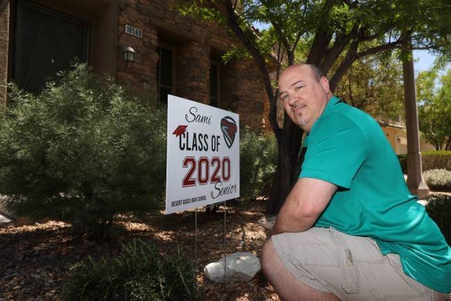 Steve Rosenthal poses after delivering a yard sign to the home of a Liberty High School senior ...