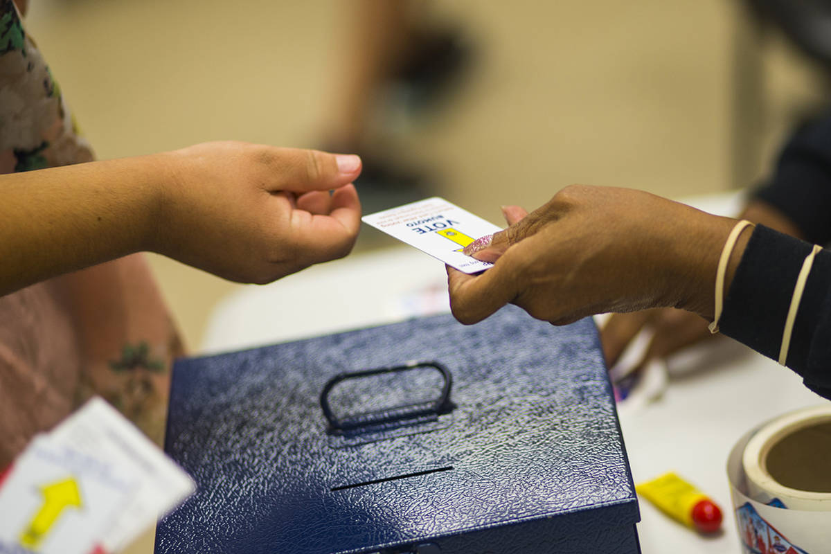 Louise Daniels, right, takes voting cards from voters at a polling station at Doolittle Communi ...