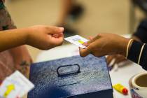 Louise Daniels, right, takes voting cards from voters at a polling station at Doolittle Communi ...