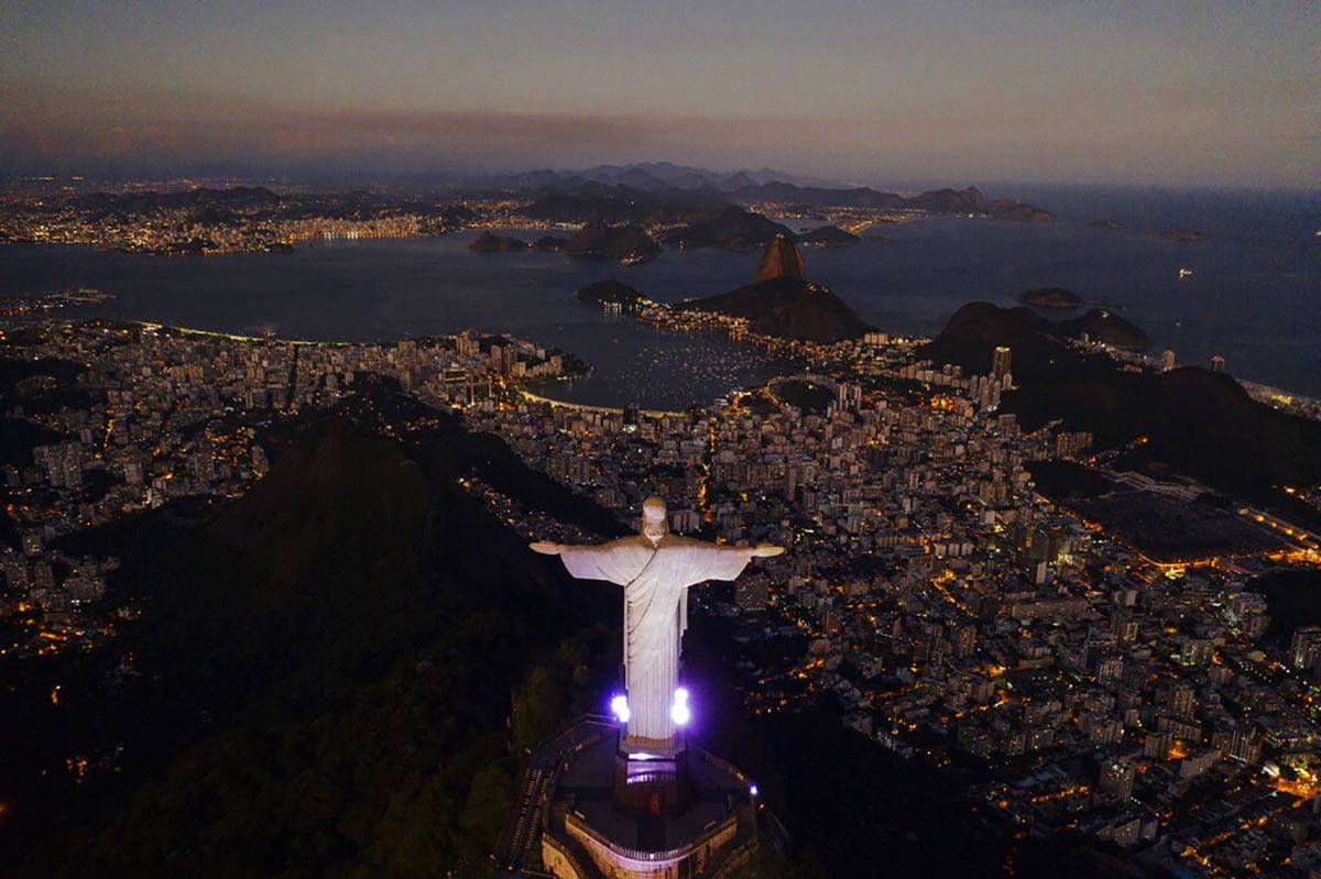The Christ the Redeemer statue stands above the Guanabara bay during dusk amid the outbreak of ...