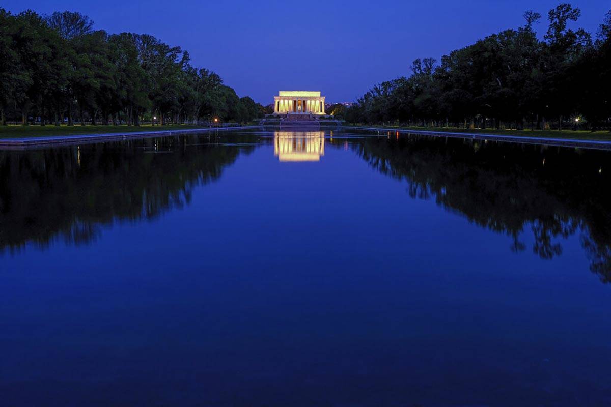 The Lincoln Memorial is reflected in the still waters of the reflecting pool on the National Ma ...