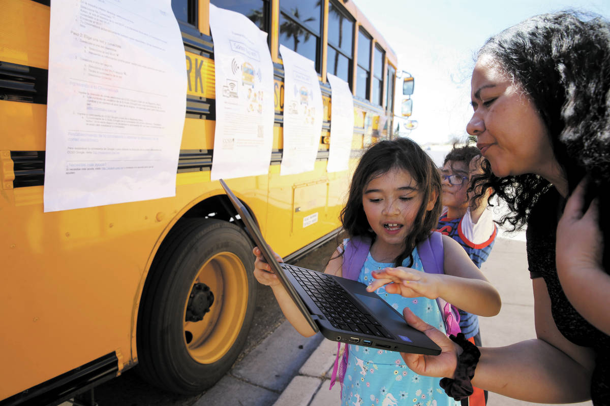 Paula Santana, 7, and her mother Maria work on homework at the Clark County School District Wi- ...
