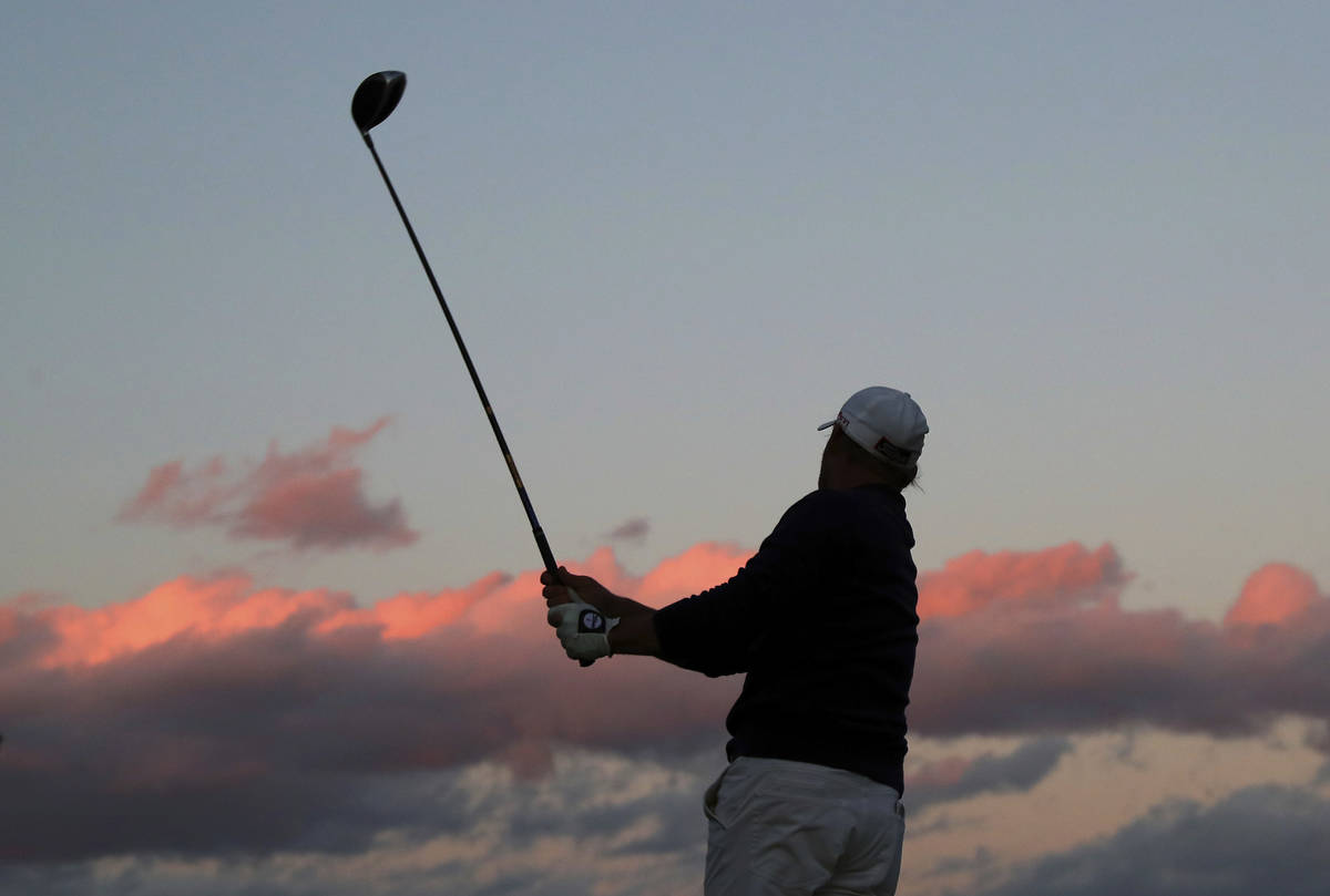 Alex Cejka, of Germany, watches his tee shot on the 18th hole as the sun sets during the third ...