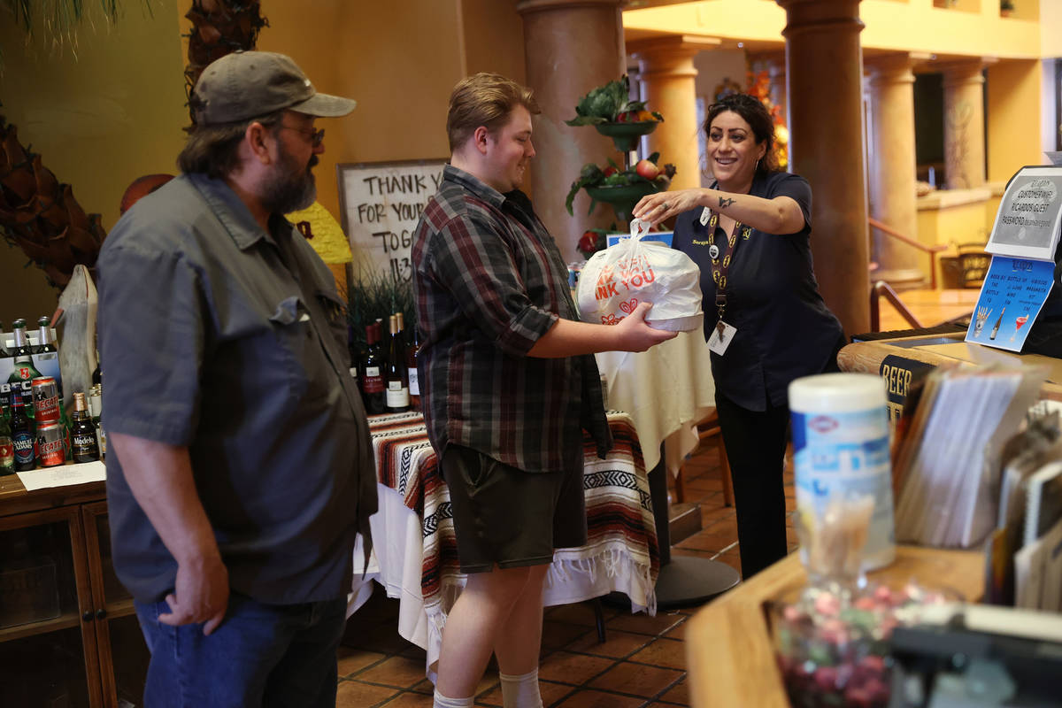 James Redensek, from left and his son also James, pick up their food order from restaurant mana ...