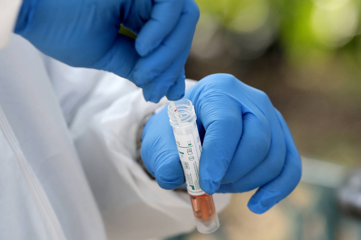 FILE - In this April 16, 2020, file photo, a medical worker places a swab in a vial while testi ...