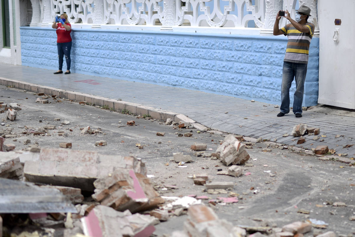 Residents, wearing protective face masks as a precaution against the spread of the new coronavi ...