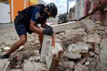 A police officer, wearing a protective face mask as a precaution against the spread of the new ...