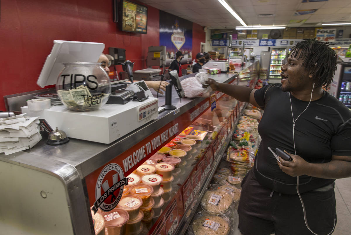 Customer Jade Mathieu picks up his chicken purchase at the Los Primos Meat Market on Sunday, Ma ...