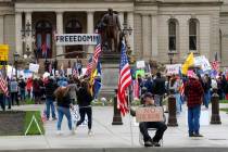 In this April 30, 2020, photo, protesters rally at the State Capitol in Lansing, Mich. Gun-carr ...