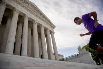 A man exercises on the steps of the Supreme Court where the justices will hold arguments by tel ...