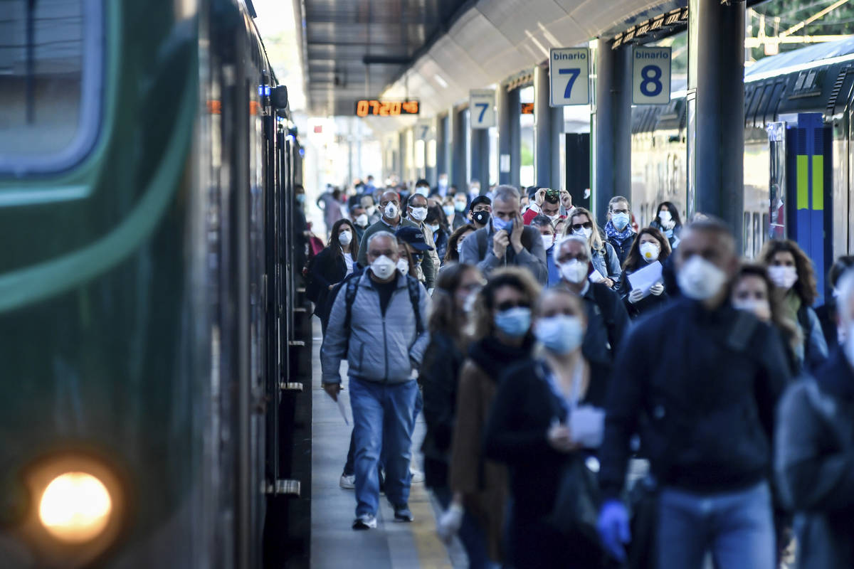 Commuters crowd Cadorna train station in Milan, Italy, Monday, May 4, 2020. Italy began stirri ...