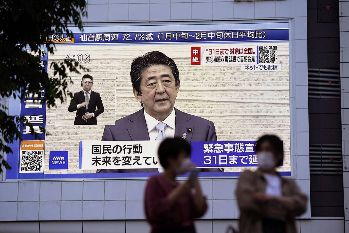A huge monitor shows Japanese Prime Minister Shinzo Abe's press conference, in Tokyo Monday, Ma ...