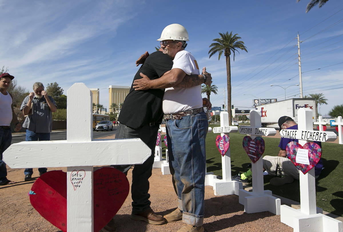 Cross maker Greg Zanis, right, gets a hug from Mike Warino, brother of Oct.1 shooting victim He ...
