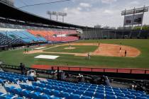 Photographers and TV camera work near empty seats during the pre-season baseball game between D ...