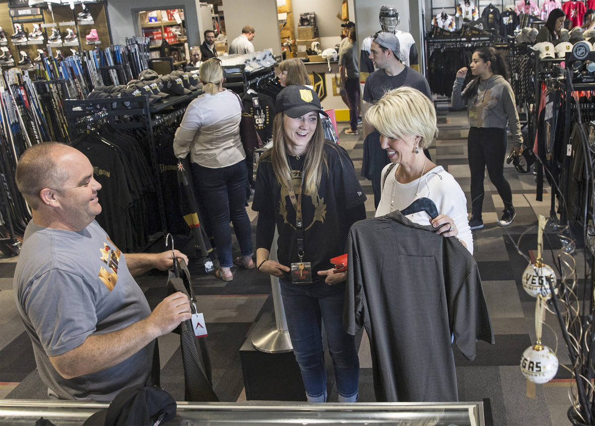 Brian Baker, left, Anna Sommers and Debbie Ikirt talk Golden Knights gear on Wednesday, April 1 ...