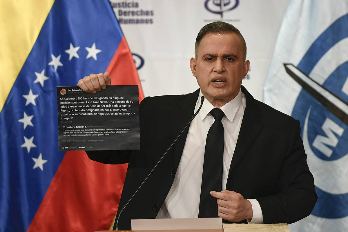 Venezuela's Attorney General Tarek William Saab holds up twitter posts during a press conferenc ...