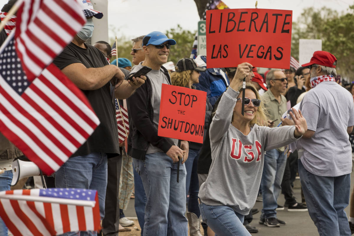 Protester Lauren Robison welcomes others arriving to the Re-Open Nevada protest at the Grant S ...