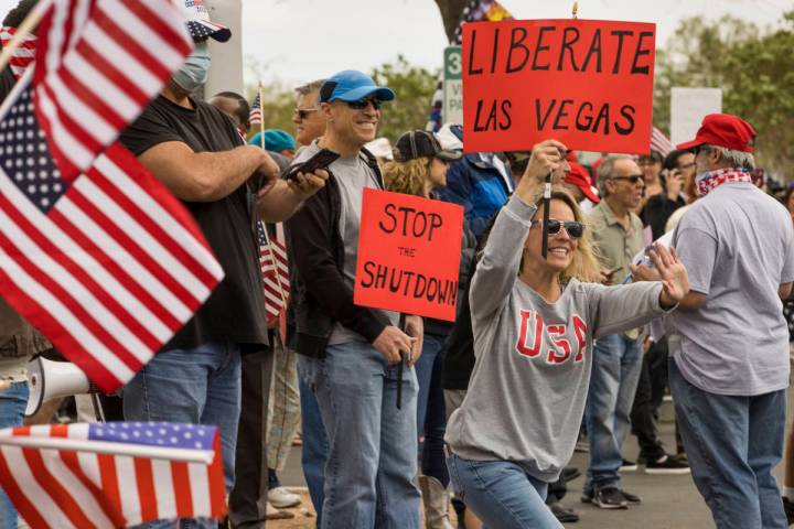 Protester Lauren Robison welcomes others arriving to the Re-Open Nevada protest at the Grant S ...