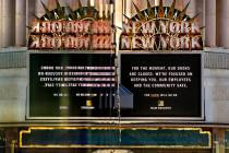 A New-York New-York sign is reflected in pedestrian bridge glass along Las Vegas Boulevard on t ...