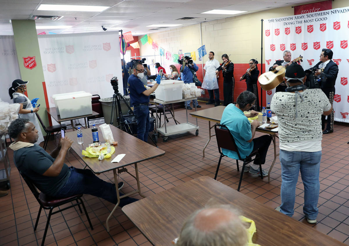 Individuals enjoy a live mariachi band during a community lunch for a Cinco de Mayo celebration ...