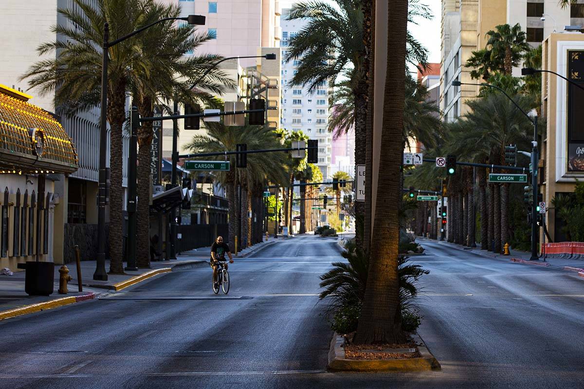 A man rides a bike down Casino Center Boulevard near Fremont Street as traffic remains light in ...