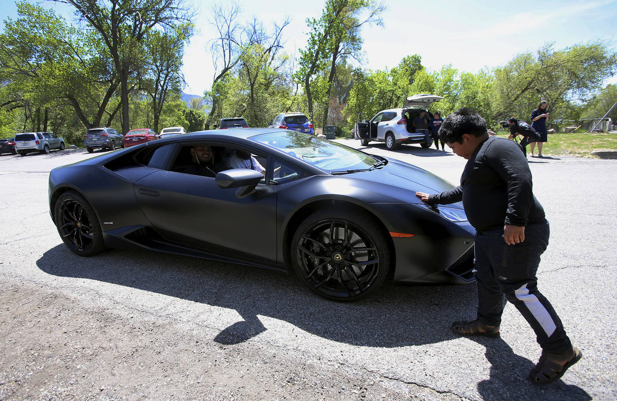Adrian Zamarripa touches the front of Jeremy Neves' Lamborghini Huracan in Ogden, Utah, Tuesday ...