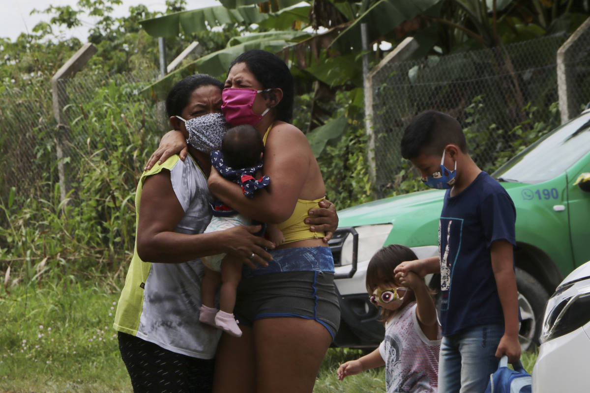 Relatives mourn at the roadside while waiting for funerary service workers to pick up of the bo ...