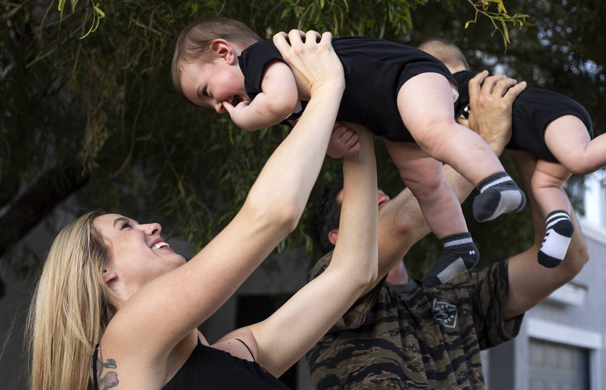 Shannon and David Belford play with their 9-month-old twin sons, Gavin and Garrett, outside the ...