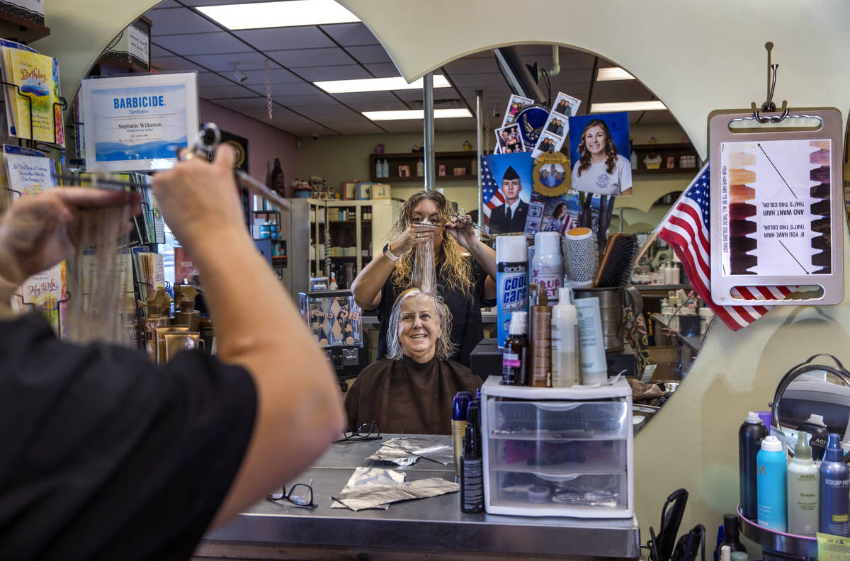 Owner Stephanie Wilkerson, top, cuts the hair of customer Louise Bustillos as business resumes ...