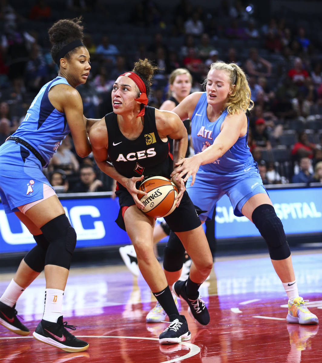 Las Vegas Aces' Dearica Hamby, center, looks to shoot under pressure during the second half of ...