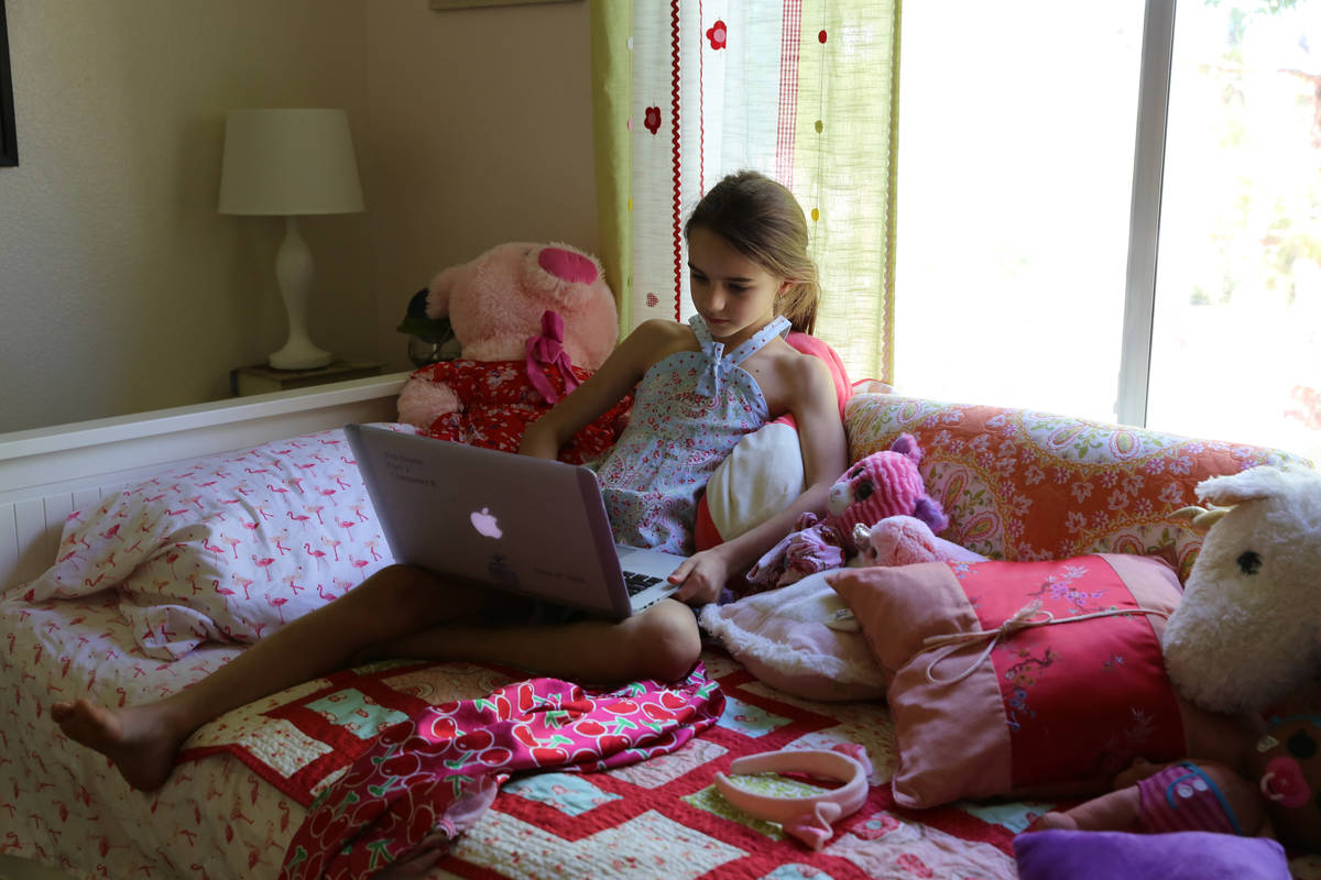 Ginger Finfrock, a second-grade student at The Alexander Dawson School, does schoolwork at home ...