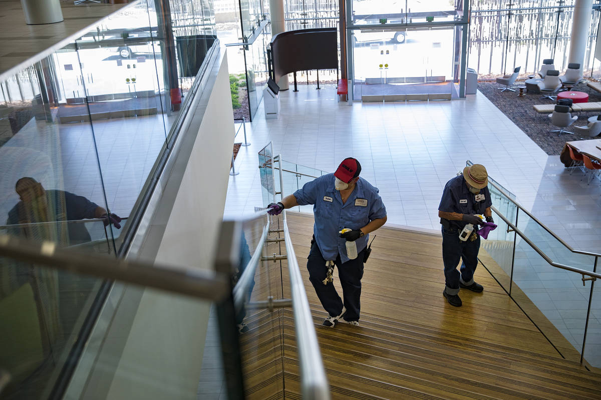 Robert Lucas, left, a custodian supervisor, and custodian Jarrell Siler, right, sanitize handra ...