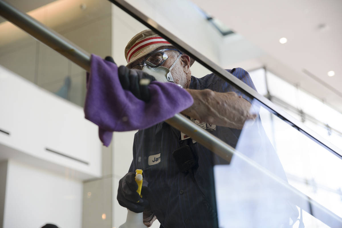 Custodian Jarrell Siler sanitizes handrails in the Hospitality Hall at UNLV in Las Vegas, Thurs ...