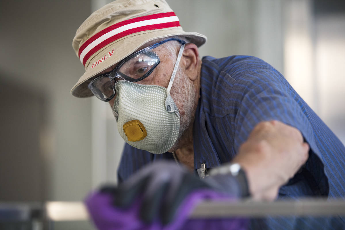Custodian Jarrell Siler sanitizes handrails in the Hospitality Hall at UNLV in Las Vegas, Thurs ...
