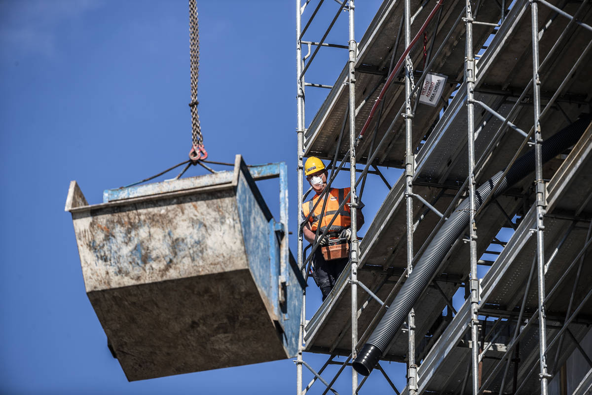 A worker operates at a construction site in Milan, Italy, Thursday, May 7, 2020. Italy began st ...
