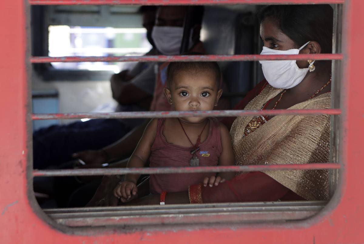 A child looks on as a special train transporting migrant workers to Bihar leaves Thane, in the ...