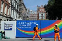 A construction worker passes a sign thanking the NHS in London, as the country in is lockdown t ...