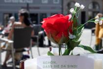 Restaurant guests relax behind a rose after the reopening of beer gardens in Weimar, central Ge ...