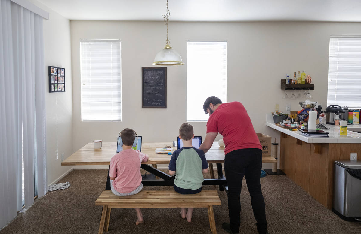 Atticus Mayville, 7, left, and Everett Mayville, 7, work on school projects with help from thei ...