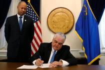 Nevada Gov. Steve Sisolak signs his first executive order. (Cathleen Allison/Las Vegas Review-J ...