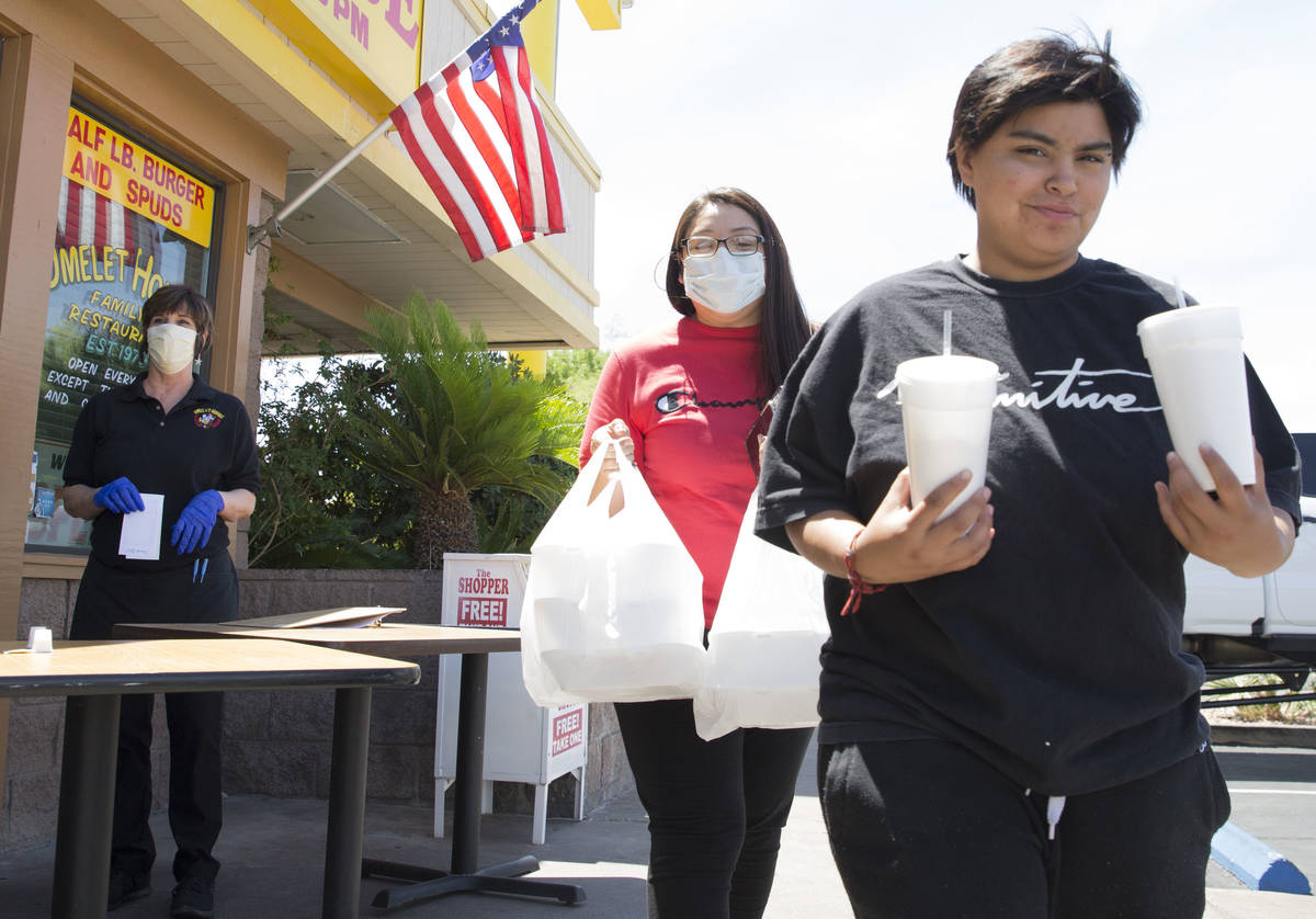 Amanda Sanchez, center, and her daughter Destiny Torres pick up their order from a curbside pic ...
