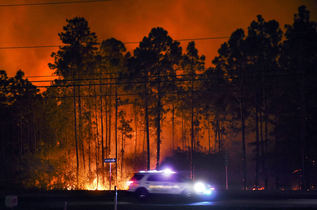 In this Wednesday evening, May 6, 2020 photo, a sheriff's vehicle travels along U.S. Highway 9 ...