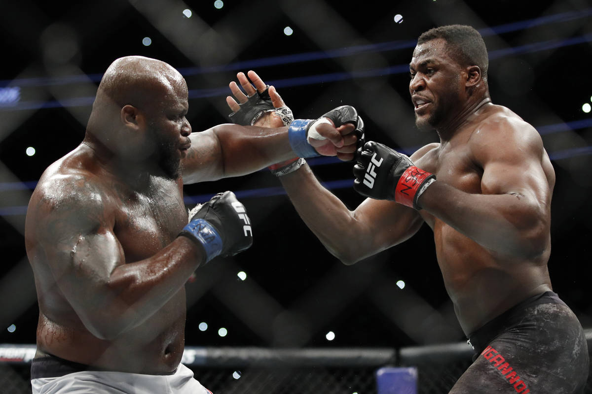 Francis Ngannou, right, fights Derrick Lewis during a heavyweight mixed martial arts bout at UF ...