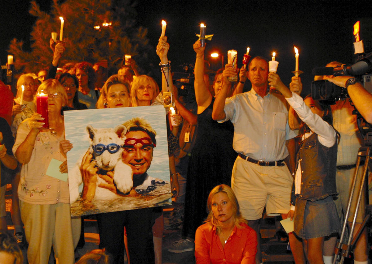 Well wishers stand outside University Medical Center Trama Center during a candlelight vigil he ...