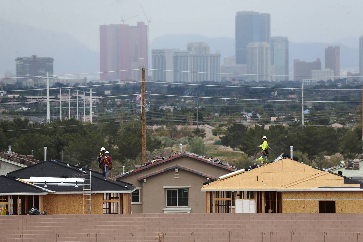 Construction workers install the roof of new homes near S Hollywood Boulevard and E Vegas Valle ...