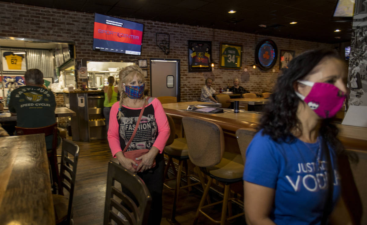 Customers Sandi Olson, left, and Terry Armstrong enter the dining area at Johnny Mac's Sports B ...