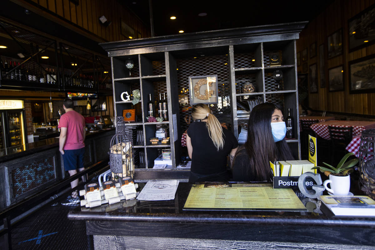 Hostess Jackeline Rodriguez, right, talks about reservations at Grimaldi's in Boca Park as some ...