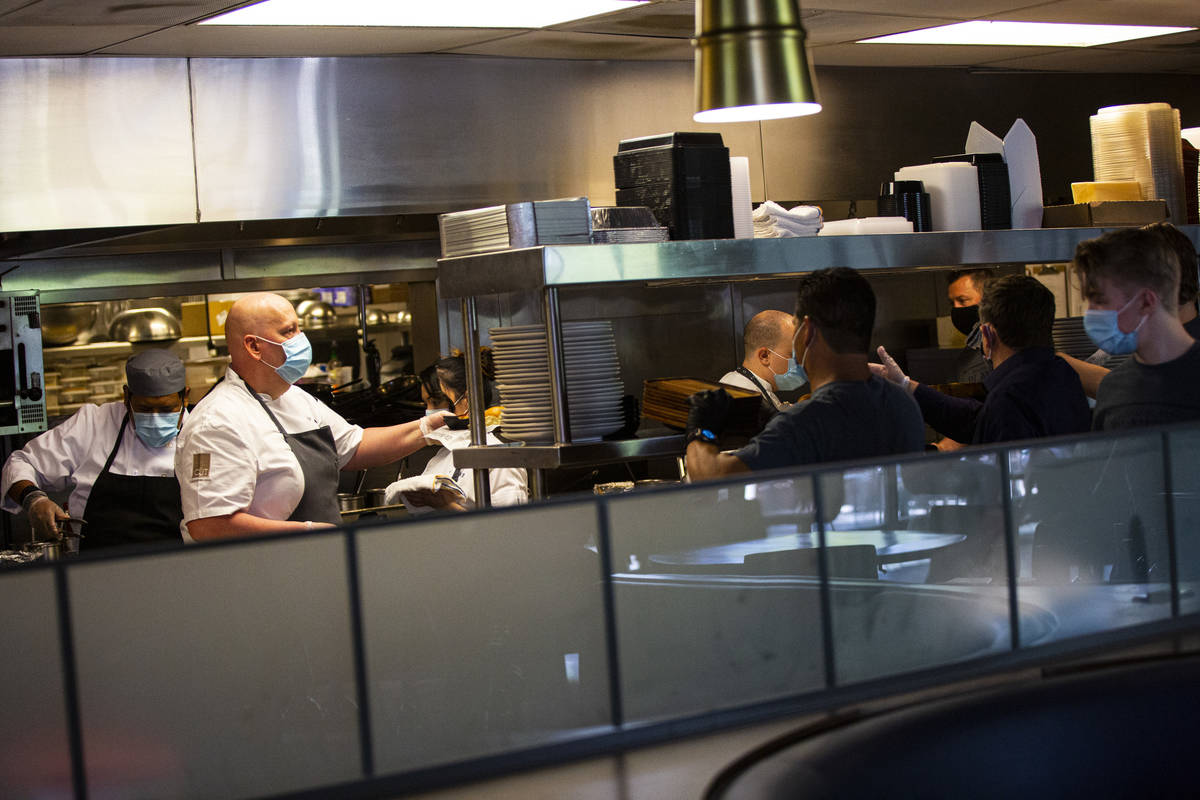 Matt Hurley, executive chef of CUT by Wolfgang Puck, left, prepares food at Wolfgang Puck Playe ...
